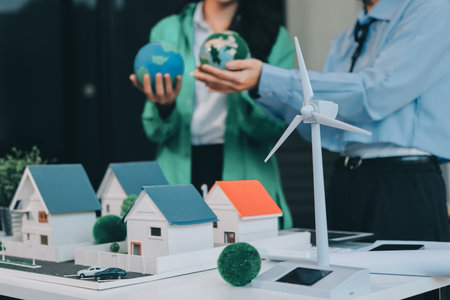 Hands of adult Asian business professionals analyzing ESG financial data and renewable energy...