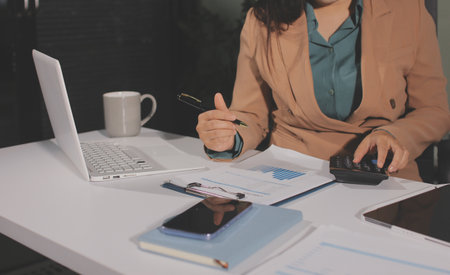 Close-up of hands making notes, chart, desk, officeの写真素材