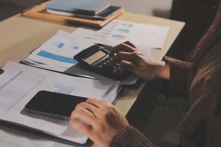 Close-up of businessman's hands making notes, chart, desk, office
