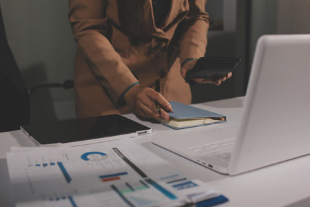 Close-up of businessman's hands making notes, chart, desk, officeの写真素材