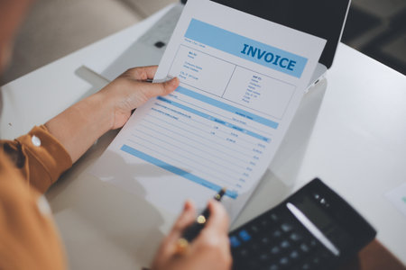 Business woman using calculator to calculate financial report, working at office with laptop computer on table. Asian female accountant or banker making calculations. finances and economy conceptの写真素材