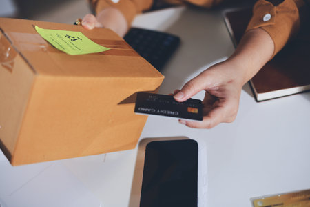 Online payment, Hands of woman holding a credit card and using smart phone for online shoppingの写真素材