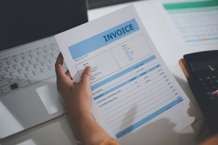 Business woman using calculator to calculate financial report, working at office with laptop computer on table. Asian female accountant or banker making calculations. finances and economy conceptの写真素材