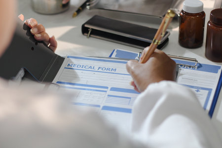 Medical team having a meeting with doctors in white lab coats and surgical scrubs seated at a table...