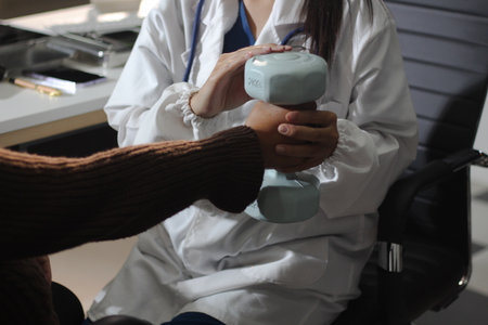 doctor is checking for muscle injuries and using dumbbells test injury and also help with physical therapy strengthen muscles because physical therapy will help strengthen muscles and help blood flowの写真素材