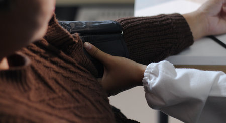 A doctor's hands carefully taking a patient's blood pressure using a sphygmomanometer.