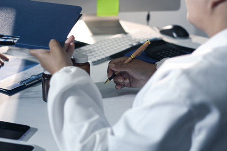Medical team having a meeting with doctors in white lab coats and surgical scrubs seated at a table...