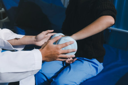 Unrecognizable person uses blue hand weight during physical therapy session