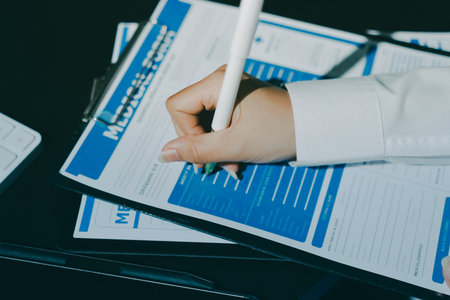 Two doctors and a female nurse meet at a table in the hospital, collaborating on medical tasks using laptops and computersの写真素材