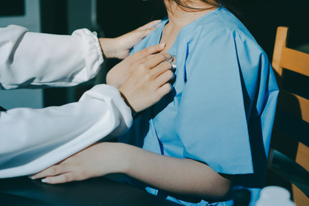 healthy concept; Doctor checking patient's heart with stethoscope at a hospitalの写真素材