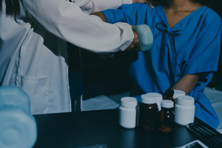 Physical therapist assisting a woman with dumbbell exerciseの写真素材