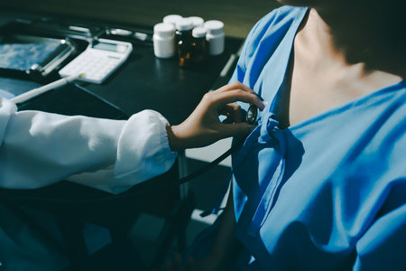 healthy concept; Doctor checking patient's heart with stethoscope at a hospitalの写真素材