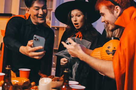 Friends enjoying a Halloween party at a bar making a toastの写真素材