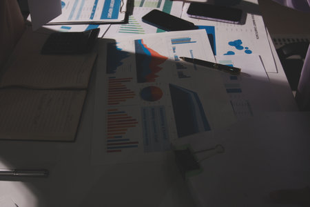 Above table with finance papers, graphs and big data during teamwork meeting with accounting or...