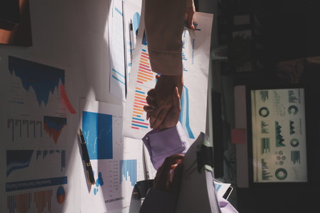 Above table with finance papers, graphs and big data during teamwork meeting with accounting or...