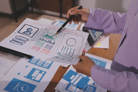 Close up ux developer and ui designer brainstorming about mobile app interface wireframe design on...