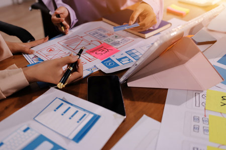 Close up ux developer and ui designer brainstorming about mobile app interface wireframe design on...