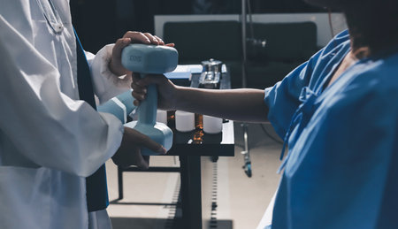 Physical therapist assisting a woman with dumbbell exerciseの写真素材