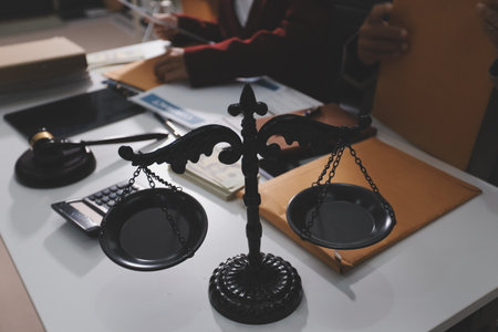 Judge gavel with Justice lawyers having team meeting at law firm in background. Notary with client in officeの写真素材