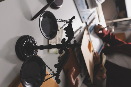 Judge gavel with Justice lawyers having team meeting at law firm in background. Notary with client in officeの写真素材