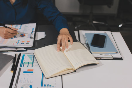 Businesswomen analyzing financial data, discussing investment strategy in office