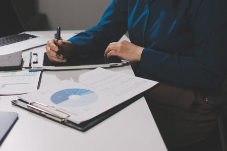 Businesswomen analyzing financial data, discussing investment strategy in office