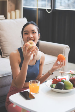 Fit young Asian women in activewear eating fresh vegetable salad after workout, representing clean eating, fitness lifestyle, wellness routine and health balance.の写真素材
