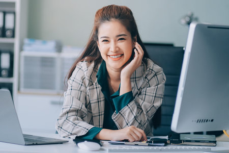 Cheerful business lady working on laptop in office, Asian happy beautiful businesswoman in formal...