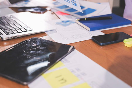 Close up ux developer and ui designer brainstorming about mobile app interface wireframe design on table with customer breif and color code at modern office.Creative digital development agency.の写真素材