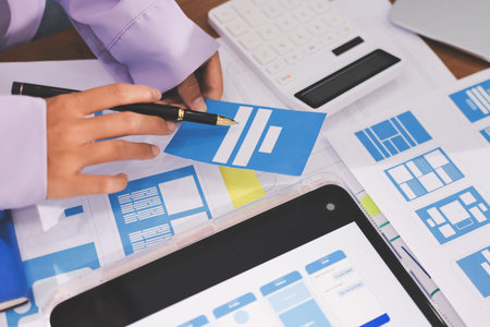 Close up ux developer and ui designer brainstorming about mobile app interface wireframe design on...