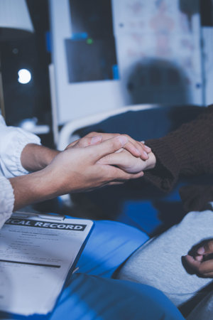 A female nurse caregiver holds hands to encourage and comfort an elderly woman. For care and trust in nursing homes for people of retirement age Caregiver helping elderly woman provides medical adviceの写真素材