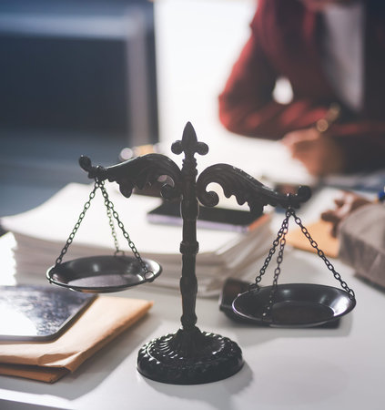 Judge gavel with Justice lawyers having team meeting at law firm in background. Notary with client in officeの写真素材