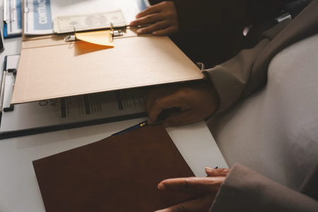 Judge gavel with Justice lawyers having team meeting at law firm in background. Notary with client in officeの写真素材