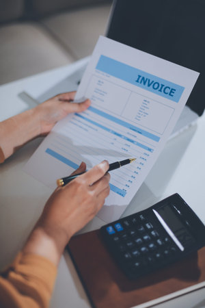 Business woman using calculator to calculate financial report, working at office with laptop computer on table. Asian female accountant or banker making calculations. finances and economy conceptの写真素材