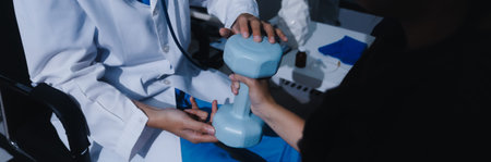 Unrecognizable uses blue hand weight during physical therapy sessionの写真素材