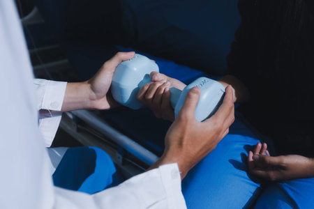Unrecognizable uses blue hand weight during physical therapy session