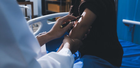 Doctor in hospital using manual blood pressure monitor to measure woman patient blood pressure and...