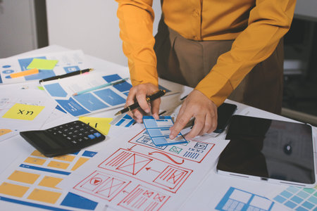 team of UI UX web designer are working together to develop mobile responsive websites with UI UX front end designer previews, UI UX web development ideas, front end designer. application developmentの写真素材