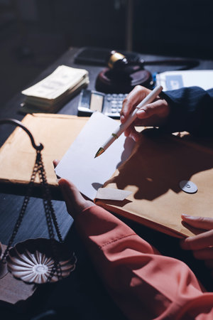 Consultation and conference of professional businesswoman and Male lawyers working and discussion having at law firm in office. Concepts of law, Judge gavel with scales of justiceの写真素材