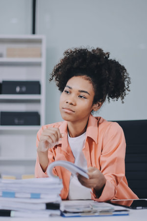 Smiling businesswoman working on laptop in officeの写真素材
