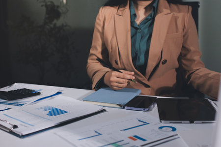 Close-up of businessman's hands making notes, chart, desk, officeの写真素材