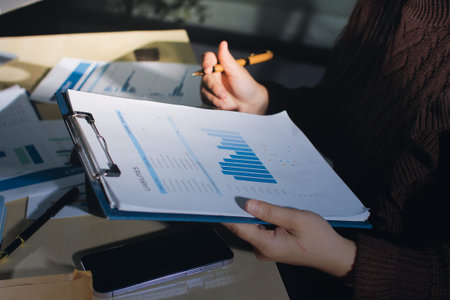 Close-up of businessman's hands making notes, chart, desk, officeの写真素材