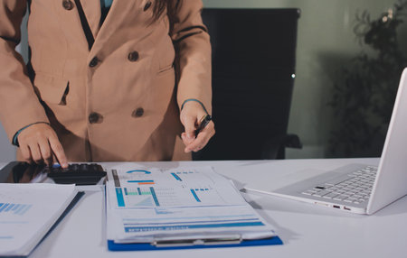 Close-up of businessman's hands making notes, mobiles, chart, desk, office