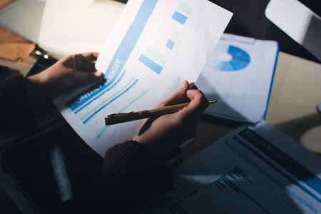 Close-up of businessman's hands making notes, mobiles, chart, desk, office