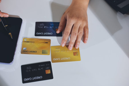 Hands of woman holding a credit card and using smart phone for online shopping