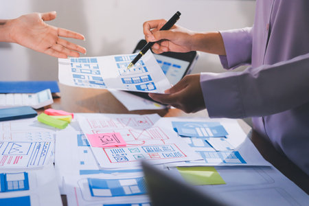 Close up ux developer and ui designer brainstorming about mobile app interface wireframe design on...