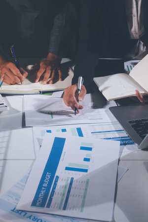 Professional photo of a person's hands reviewing a contract or legal document on a desk, for concepts of business, finance, and legal affairsの写真素材