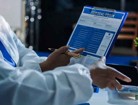 Medical team having a meeting with doctors in white lab coats and surgical scrubs seated at a table...