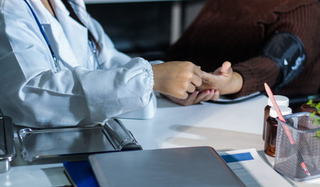 A doctor's hands carefully taking a patient's blood pressure using a sphygmomanometer.