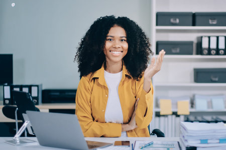 Pretty female freelancer working on laptop while sitting on modern coworking background